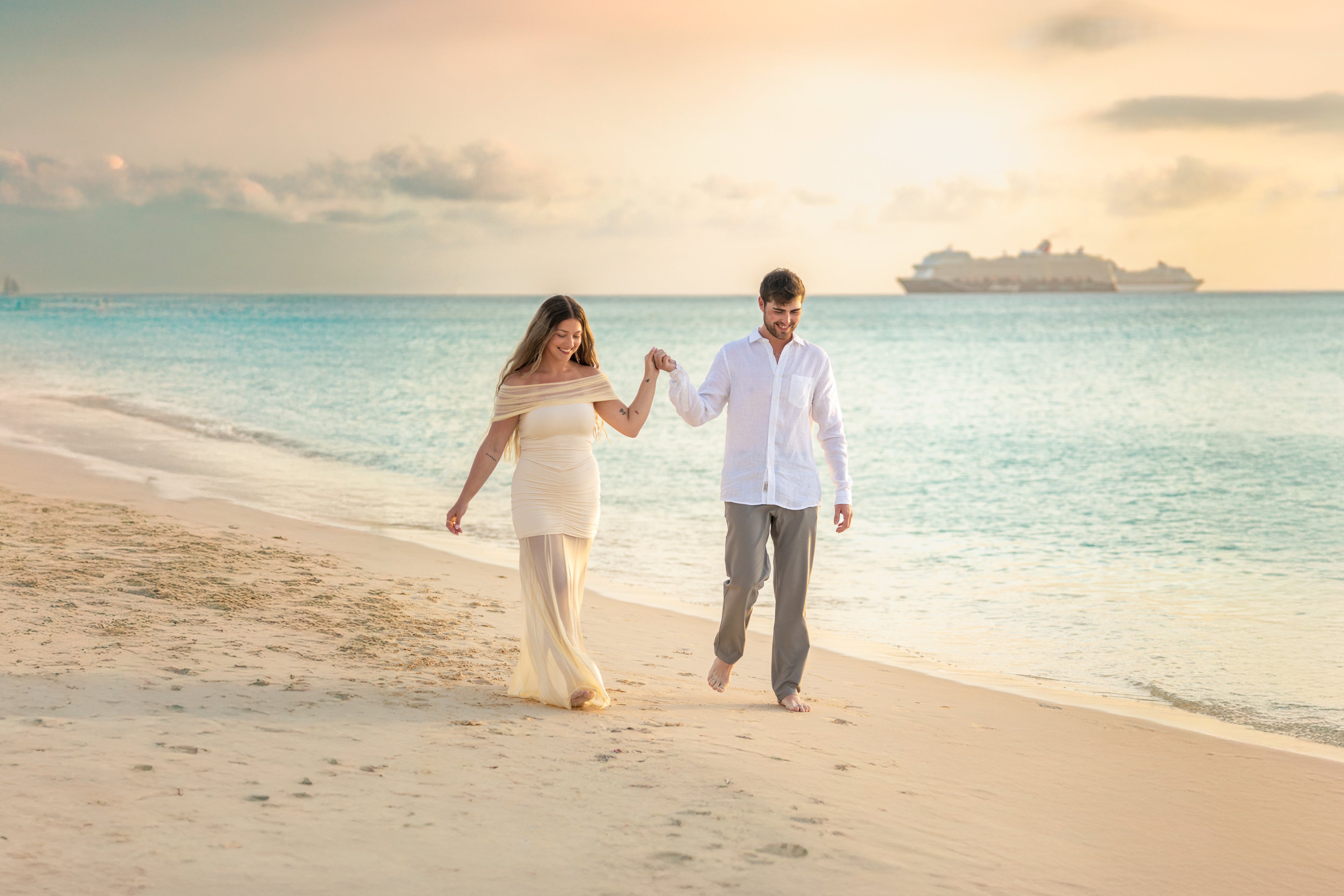 Couple walking on a beach with a cruise ship in the background. Proposal and engagement photo session in Grand Cayman
