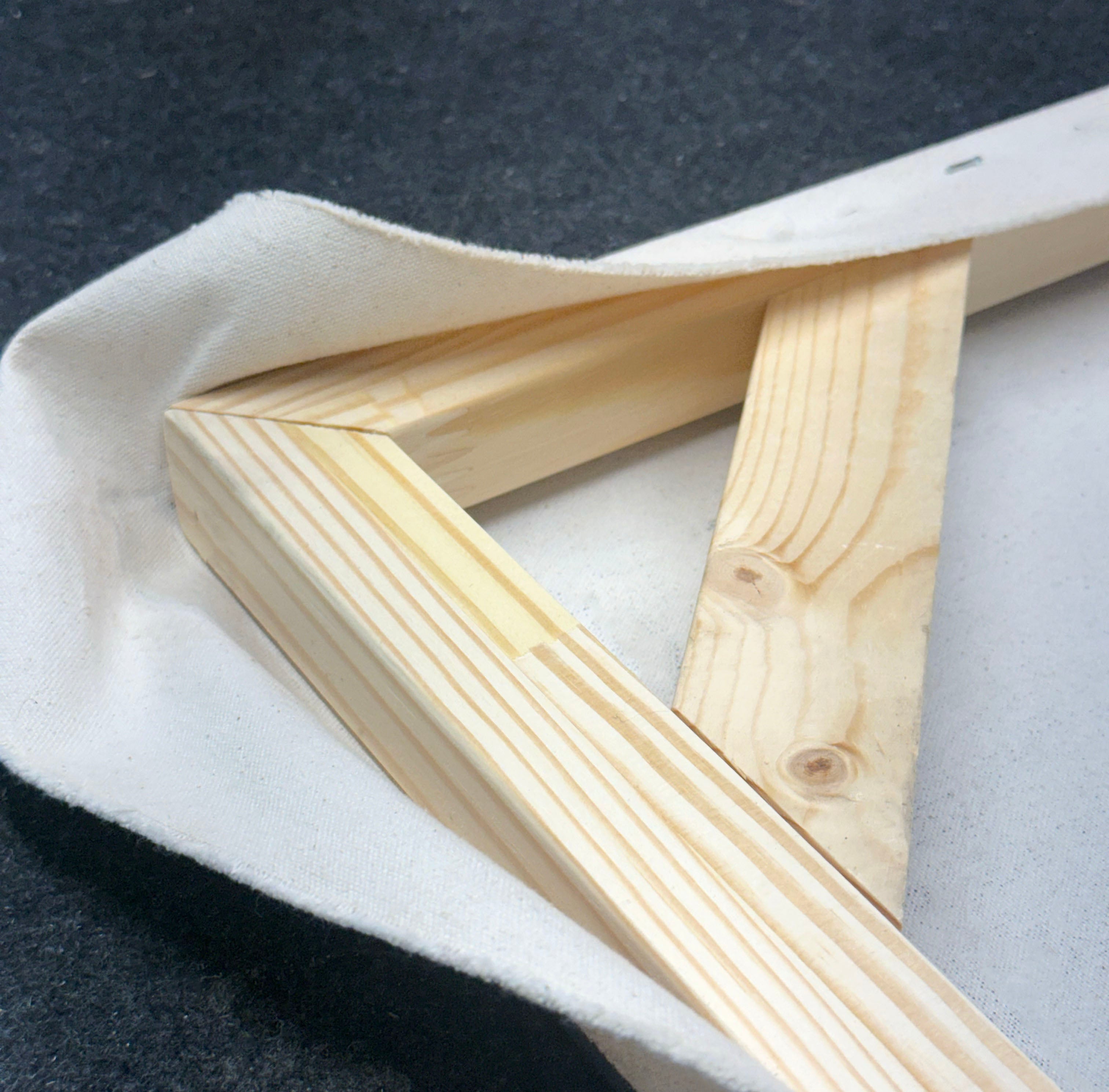 Wooden picture frame on a textured surface. Kiln dried stretchers. Cayman Islands framing service