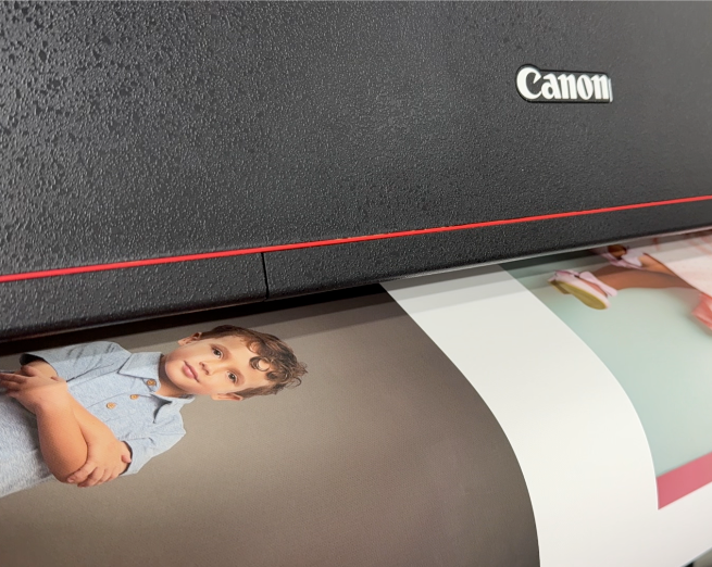 Canon printer in action with a photo of a child being printed. Printing, framing services Cayman Islands.