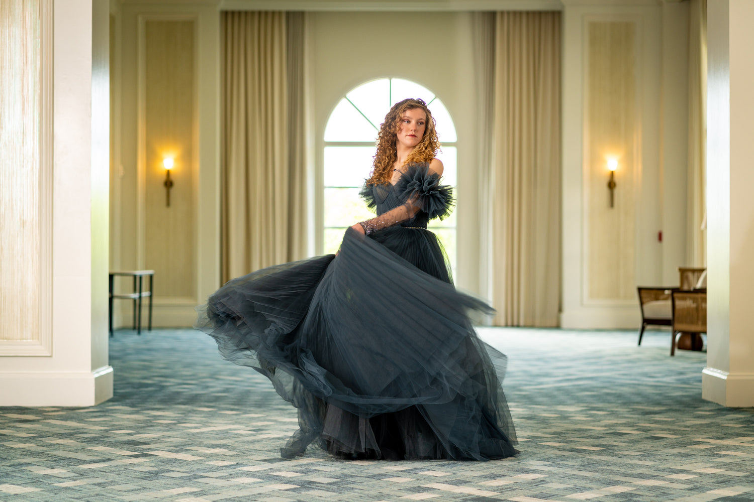 Woman in a black dress standing in the Ritz-Carlton Grand Cayman ballroom foyer for a Senior portrait session.