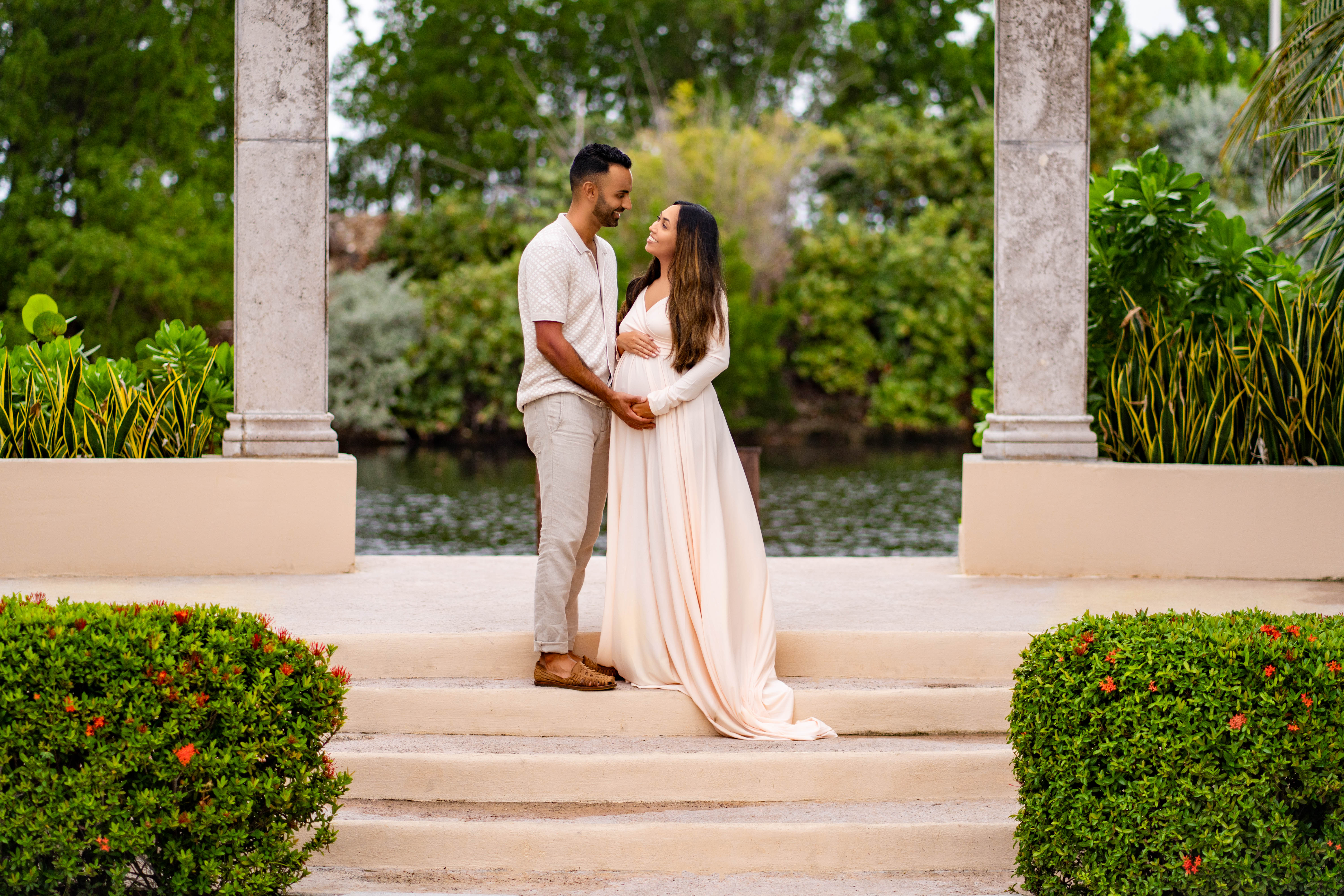 Couple standing on steps at the Ritz-Carlton Grand Cayman, during a maternity photo shoot in the Cayman Islands