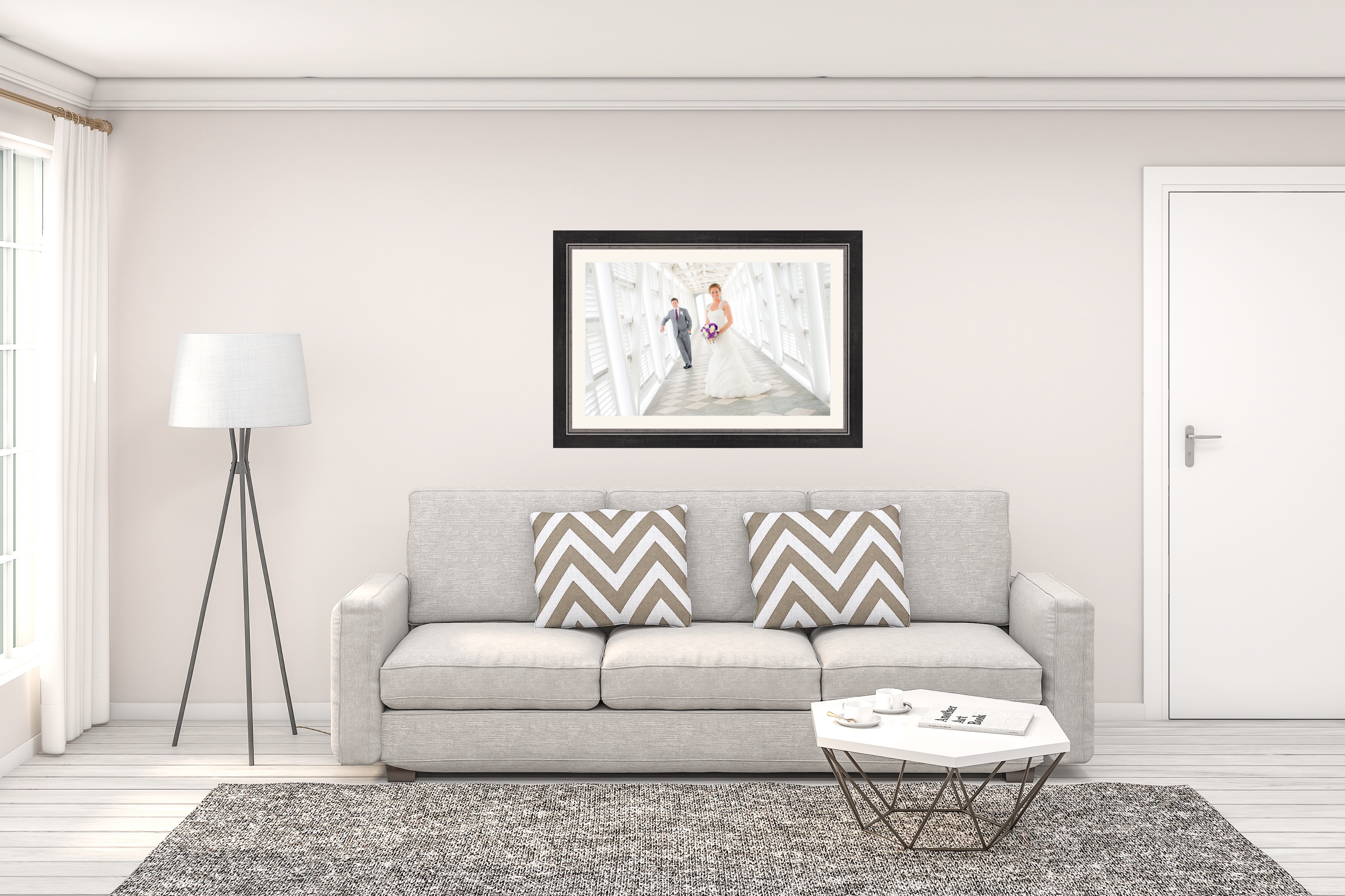 Framed photograph of a couple on a white wall above a gray sofa with decorative pillows. Cayman Islands photo printing and framing